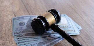 Judge’s gavel resting on a stack of US hundred-dollar bills