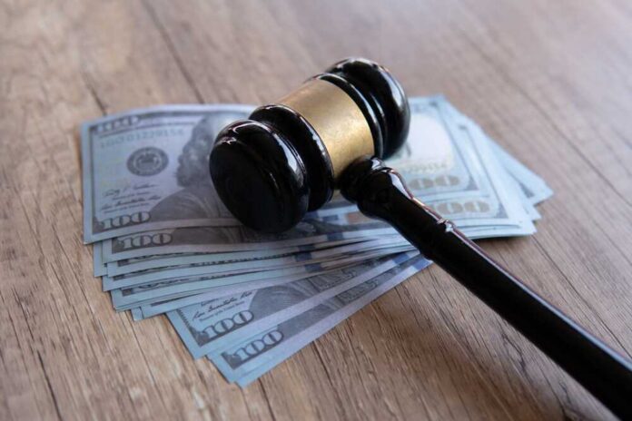 Judge’s gavel resting on a stack of US hundred-dollar bills