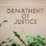 Sign displaying 'Department of Justice' on a stone wall