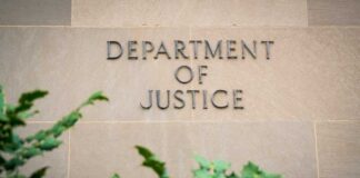 Sign displaying 'Department of Justice' on a stone wall