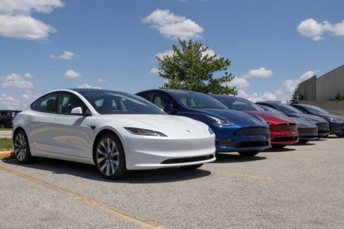 Indianapolis,-,May,30,,2024:,Tesla,Ev,Electric,Vehicles,Display. A lineup of Tesla electric vehicles parked outdoors under a blue sky