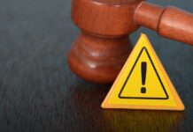 Emergency Bid Keeps Bulldozers at 1600 Judge's gavel beside yellow warning triangle sign