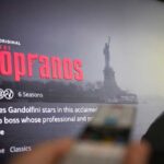 Screen displaying the HBO series The Sopranos with a remote in the foreground