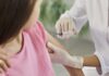 Healthcare worker gives a vaccine injection in a child's upper arm