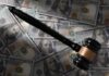 Judge’s gavel on scattered US hundred-dollar bills