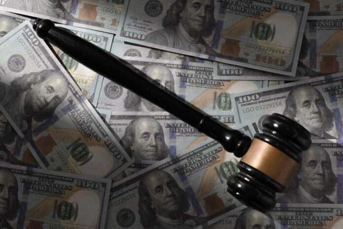 Judge’s gavel on scattered US hundred-dollar bills