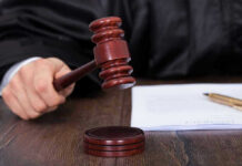 Retrial Twist Trips Up Hollywood Pervert Judges hand holding gavel next to documents.