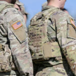 Troops Over 30 Flagged For THIS Mandatory Test Soldiers in camouflage uniforms with American flag patches.