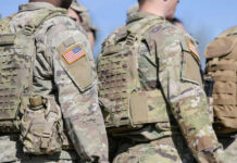 Troops Over 30 Flagged For THIS Mandatory Test Soldiers in camouflage uniforms with American flag patches.