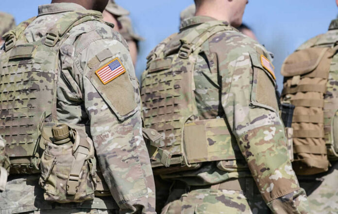 2145891607 Soldiers in camouflage uniforms with American flag patches.
