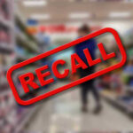 Target Recall Panic: Deadly Pearls? Recall stamp on blurred store aisle background.