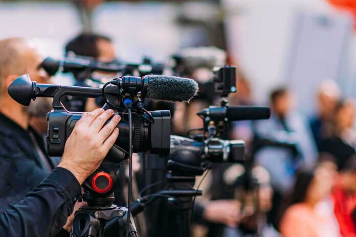 Group,Of,Cameras,At,An,Indoor,Event Video cameras on tripods at a media event