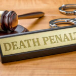 AG Pushes Death — Rolling Prison Horror Revealed Gavel handcuffs and death penalty sign on table