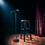 Hollywood’s Sparkle King Is Gone Empty stage with microphone and stool.