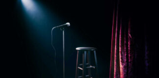 Empty stage with microphone and stool.