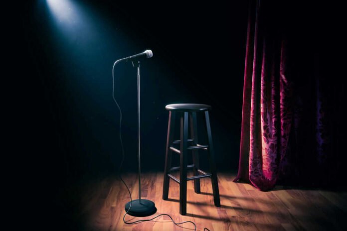 Empty stage with microphone and stool.