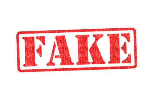 Fake,Rubber,Stamp,Over,A,White,Background. Red stamp with the word FAKE prominently displayed