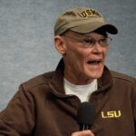 Supreme Court Twist Supercharges GOP Map James Carville speaking into a microphone wearing an LSU jacket and cap