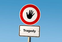 TRAGEDY: Hunter’s Shot Kills Mom In Field Road sign with hand stop symbol and a lower sign reading Tragedy