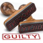 Two rubber stamps labeled guilty and innocent on a white surface