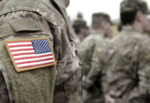 Soldiers in camouflage uniforms with American flag patches.