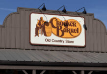 Dinner War Erupts at Cracker Barrel Sign for Cracker Barrel Old Country Store featuring a man sitting on a barrel