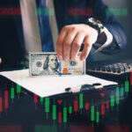 Brace For Impact: Another Hike Coming?! Businessperson holding a hundred-dollar bill over documents with stock chart overlay