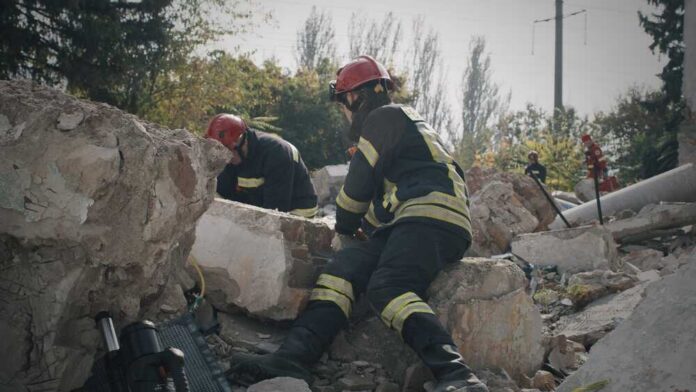 Emergency,Service,Workers,On,Ruins,Of,Building Firefighters search through rubble after a building collapse