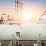 Deadly Blast, Missing Proof Gas storage tanks in an industrial facility during sunrise
