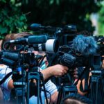 FDA Finally Blinks on Sunscreen TV news cameras crowding together at an outdoor event