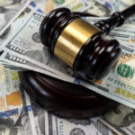 Fed Titan Dies — Verdict Still Pending Gavel on pile of hundred dollar bills