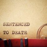 TV Star Condemned — Death by Hanging Typewriter typing the phrase 'Sentenced to Death' on aged paper