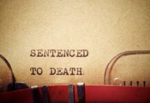 TV Star Condemned — Death by Hanging Typewriter typing the phrase 'Sentenced to Death' on aged paper