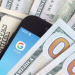 Second Facebook Checks Hit — Many Clueless Smartphone with Google app on screen among US dollar bills