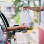PROOF: Lib City’s Forced Pay Hike Backfires Drive-thru window handing a takeout bag to a car