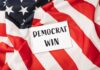 Democrats Surge: 10-Point Shocker A notepad with the words 'DEMOCRAT WIN' placed on an American flag