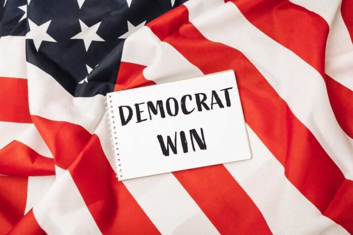 A,Red,And,White,American,Flag,With,A,White,Piece A notepad with the words 'DEMOCRAT WIN' placed on an American flag