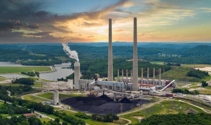 Coal-fired power plant with tall smokestacks at sunset