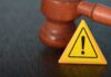 NEW Juror Bombshell Shadows Clancy Mistrial Judge's gavel beside yellow warning triangle sign