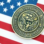 Trump’s Navy Pick Revealed Navy medal placed on an American flag background