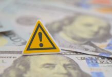 Staggering Payouts Ignite Rural Frenzy A warning sign placed on top of U.S. dollar bills