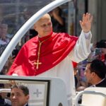 Pope’s Bombshell Jolts Globe Catholic clergyman in red vestments waving from a popemobile