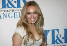 Smiling woman with long blonde hair at a media event