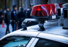 Dead Baby Horror In Hotel Spa Police car lights with officers blurred in background.