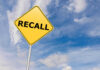 RECALL: Dangerous Shards Found in Breakfast Food Yellow sign with RECALL text against blue sky.