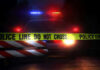 Hate-List Found After Ambush Murders Police car with flashing lights behind caution tape.