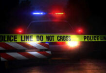 Hate-List Found After Ambush Murders Police car with flashing lights behind caution tape.