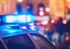 Buried Suitcase Murder Twist Shocks Investigators Close-up of a police car with blue emergency lights in a city at night
