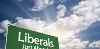 Green roadside sign against a cloudy sky