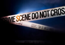 Chilling Horror: Toddler Stabbed Police tape reading 'CRIME SCENE DO NOT CROSS' in a dark setting